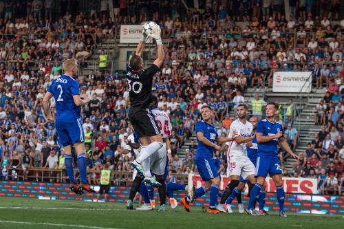 Brankář Buchta v klidu doskakuje pro centrovaný balón, jištěn Jemelkou