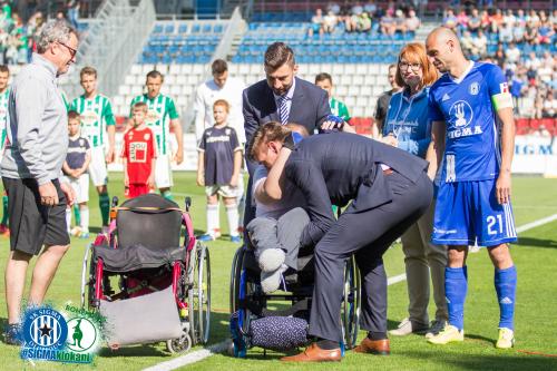 Aleš Škerle pomáhá s přenosem do nového kolečkového křesla fanynce, jež na toto hráči přispěli vysokou částkou